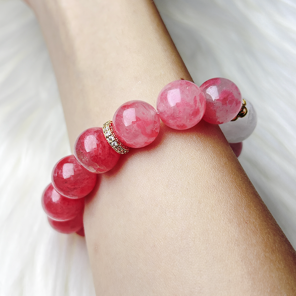 Side view of Rhodonite and Phantom Quartz bracelet with gold rhinestone spacer worn on wrist