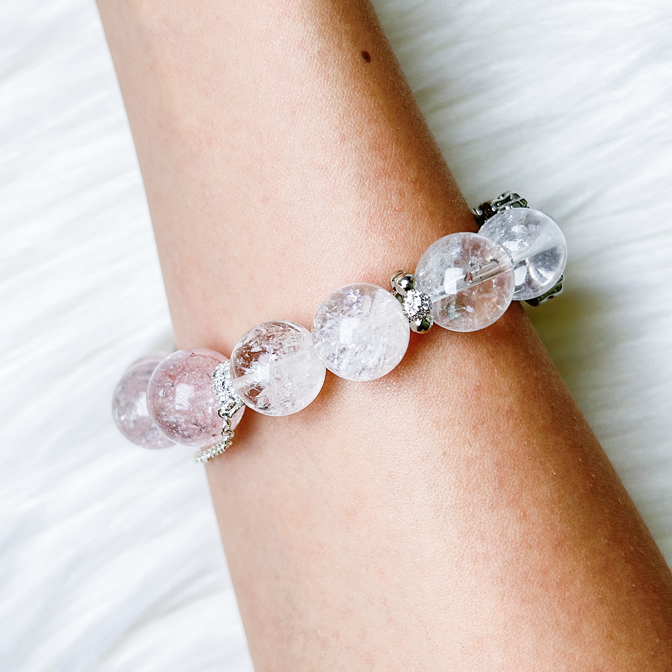 Blossom Valley bracelet worn on wrist showing gradient of clear and pink azeztulite beads.