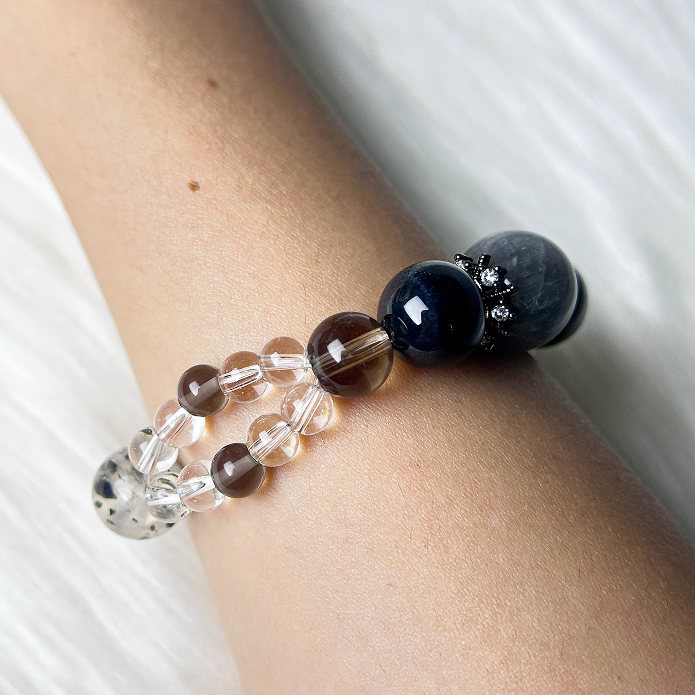 SIde view of a crystal healing bracelet with glossy Blue Tiger’s Eye and warm brown Smoky Quartz, arranged with clear beads for grounding and clarity.