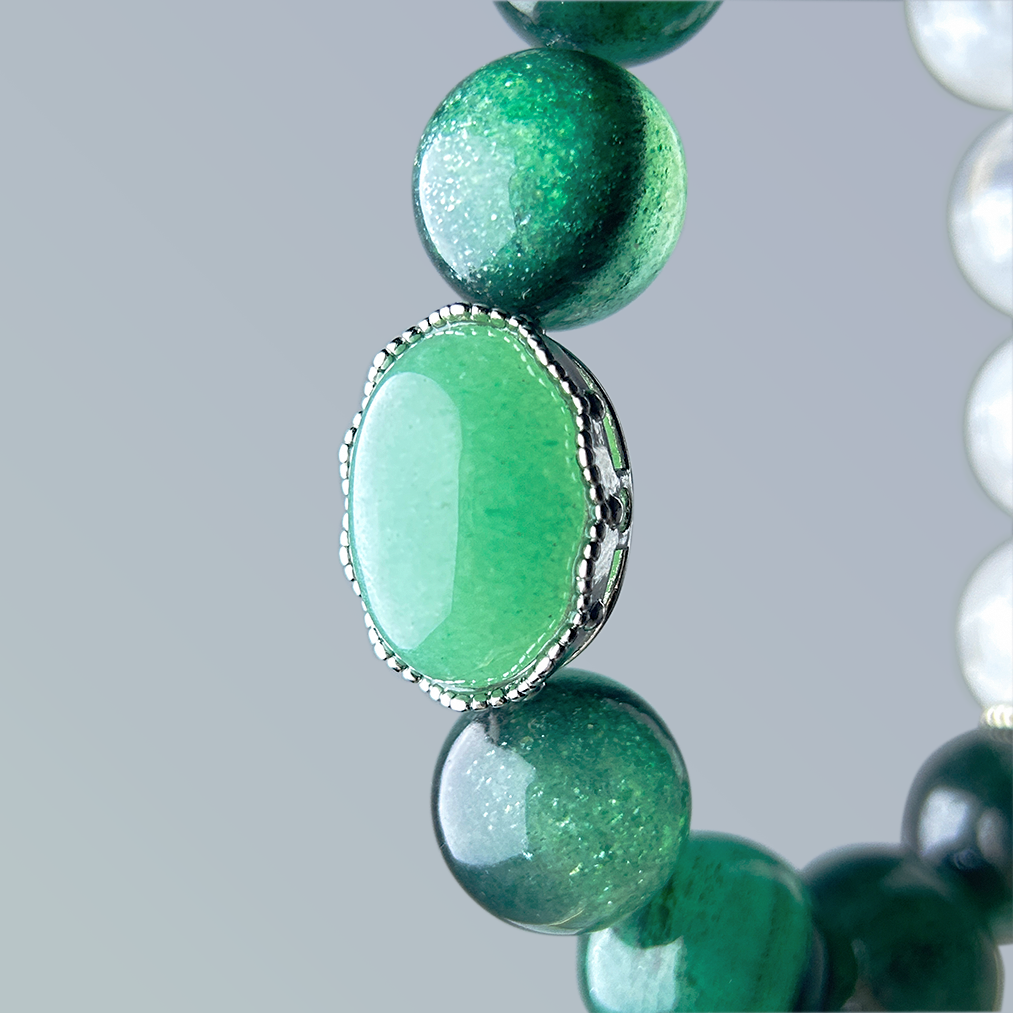 Side angle of the aventurine centerpiece in silver crown bezel, complemented by green strawberry quartz beads and adjacent white phantom quartz elements.