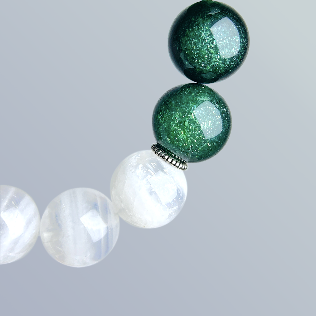 Close-up detail of green strawberry quartz and white phantom quartz beads with a metallic spacer, showcasing the bracelet’s shimmering texture and clarity.