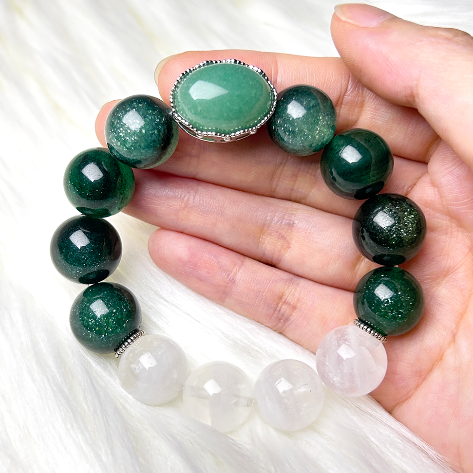 Bracelet held in hand on a white fur background, showcasing the full circle of aventurine, green strawberry quartz, and white phantom quartz beads.
