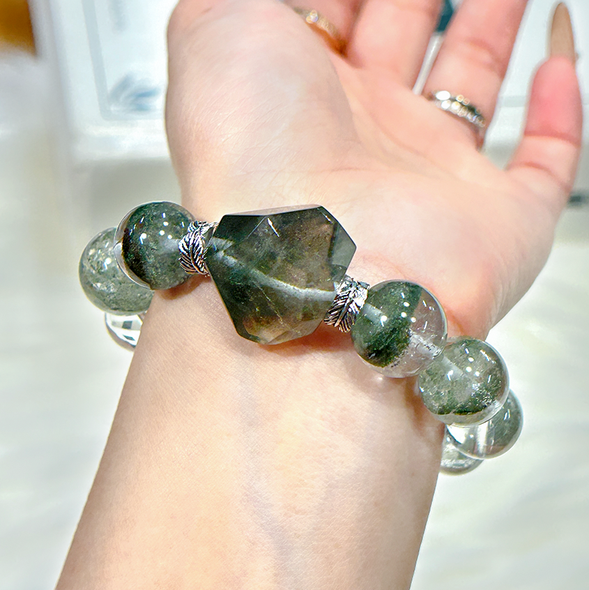 Green Phantom Quartz and Clear Quartz crystal bracelet on wrist, feminine and healing design.