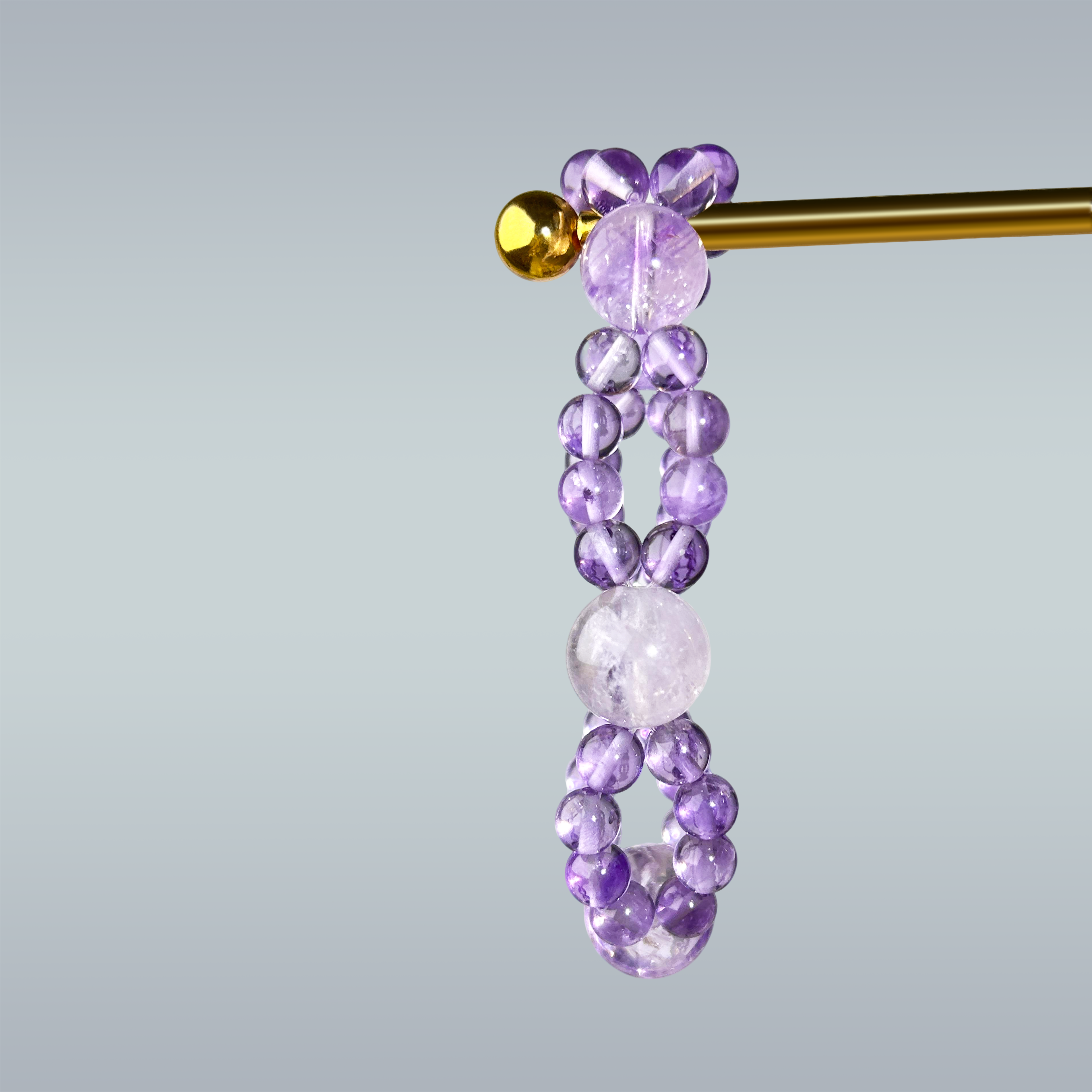 Double layered amethyst bracelet with gradient violet and clear beads on gray background