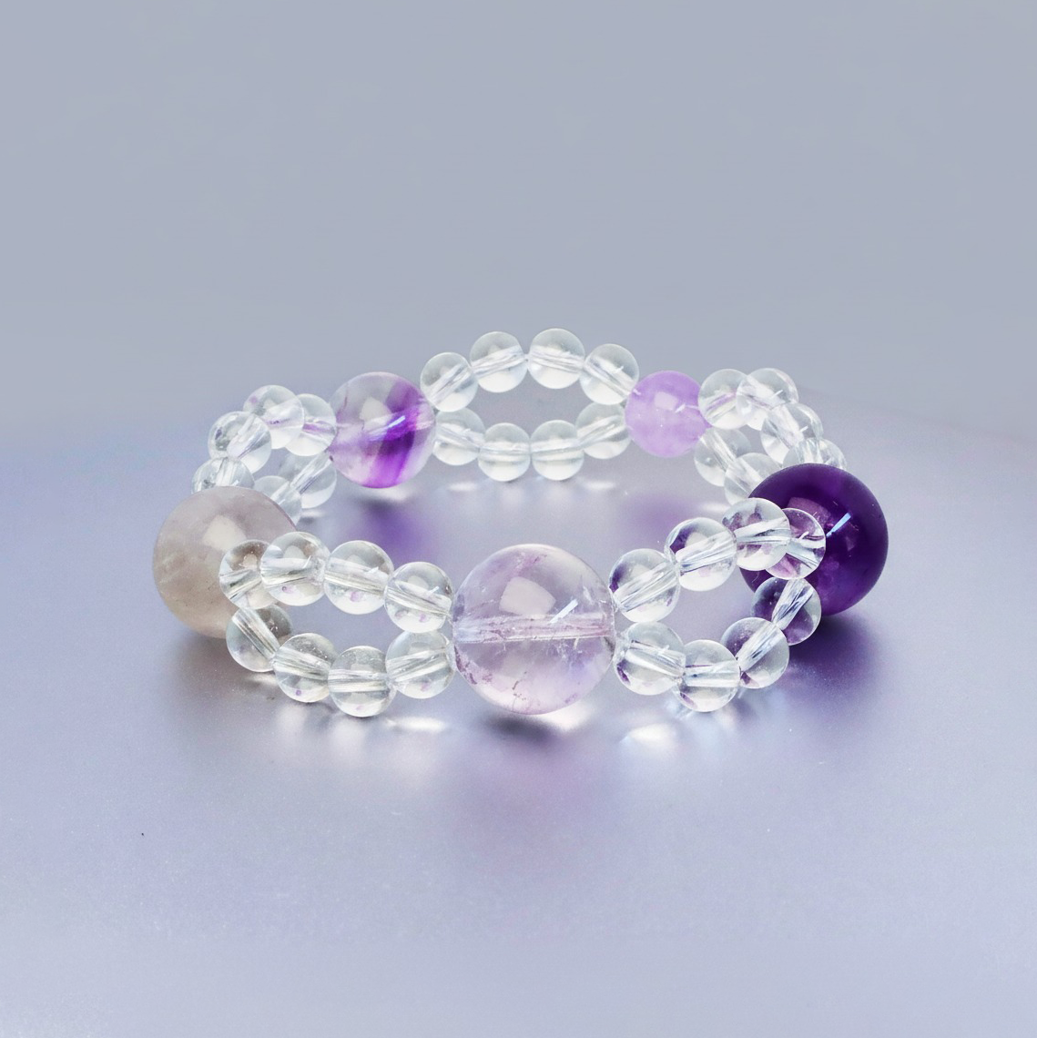 Front view of double layered bracelet made with purple crystals and clear quartz symbolizing clarity and calm