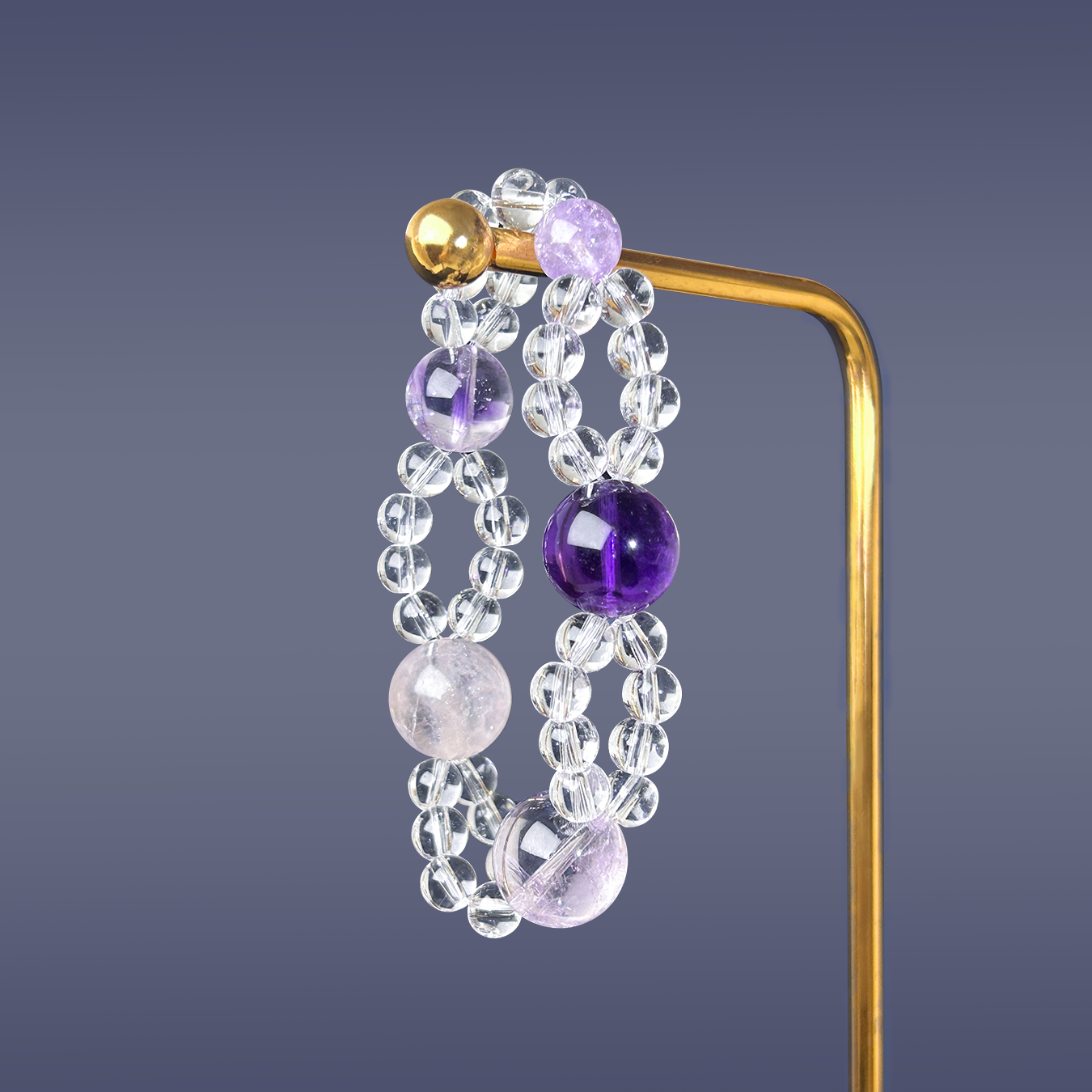 Double layered bracelet of amethyst and clear quartz on golden stand