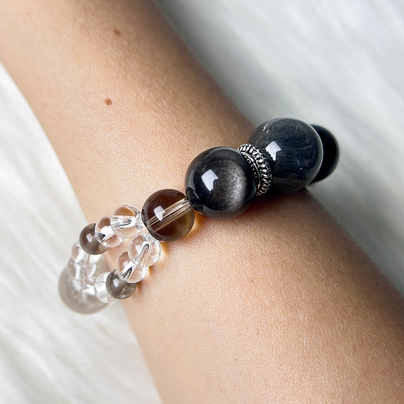 Minimalist shot of a Blue tiger's Eye and Smoky Quartz bracelet with silver spacers, captured on a wrist to highlight natural shine and healing aura.