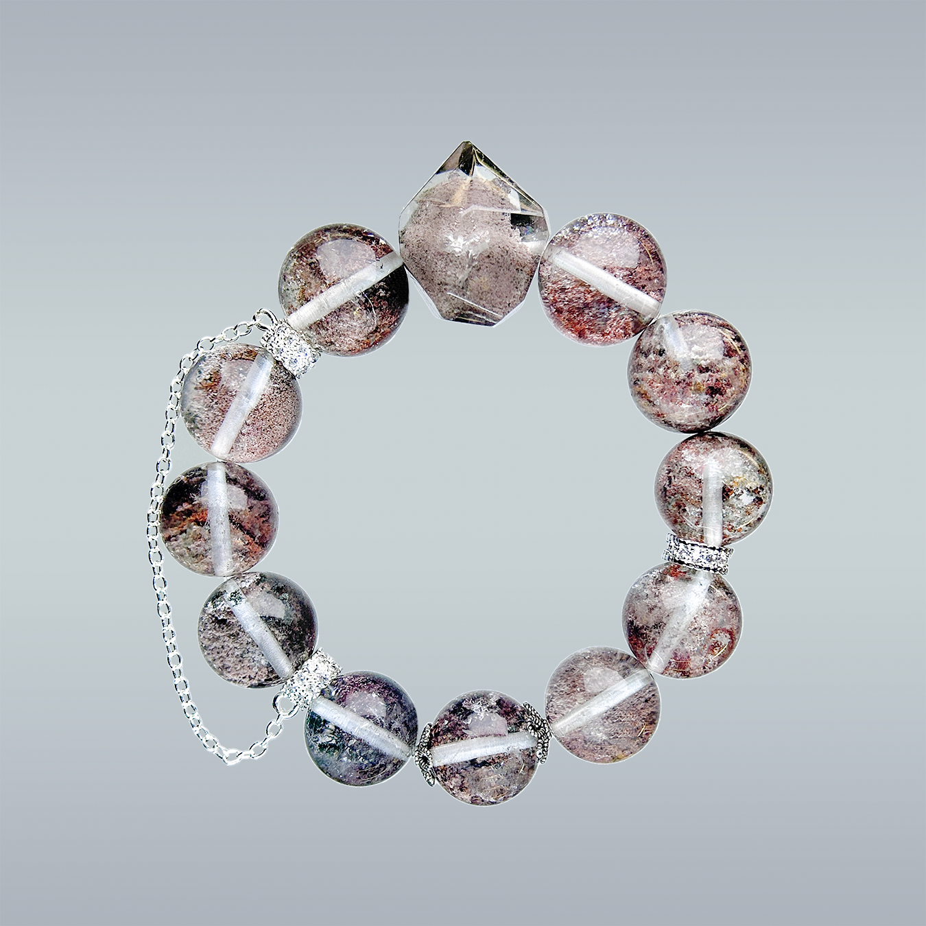 Phantom Quartz crystal bracelet in full circular layout on gradient background, featuring a pointed centerpiece and silver chain detail.