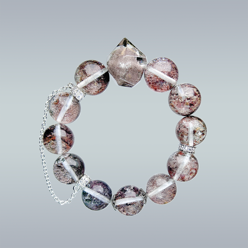 Phantom Quartz crystal bracelet in full circular layout on gradient background, featuring a pointed centerpiece and silver chain detail.