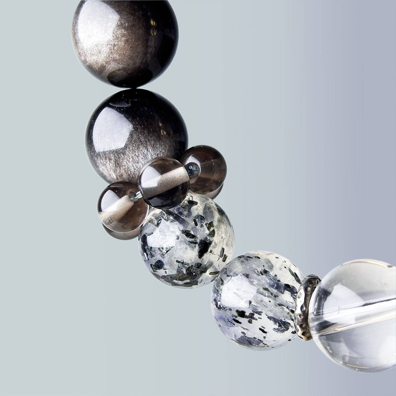 Macro close-up of Biotite Mica and smoky quartz beads showing natural texture and layered monochrome contrast