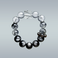 Hang-lay of Monochrome Vein bracelet in circular form displaying gradient from clear quartz to black obsidian