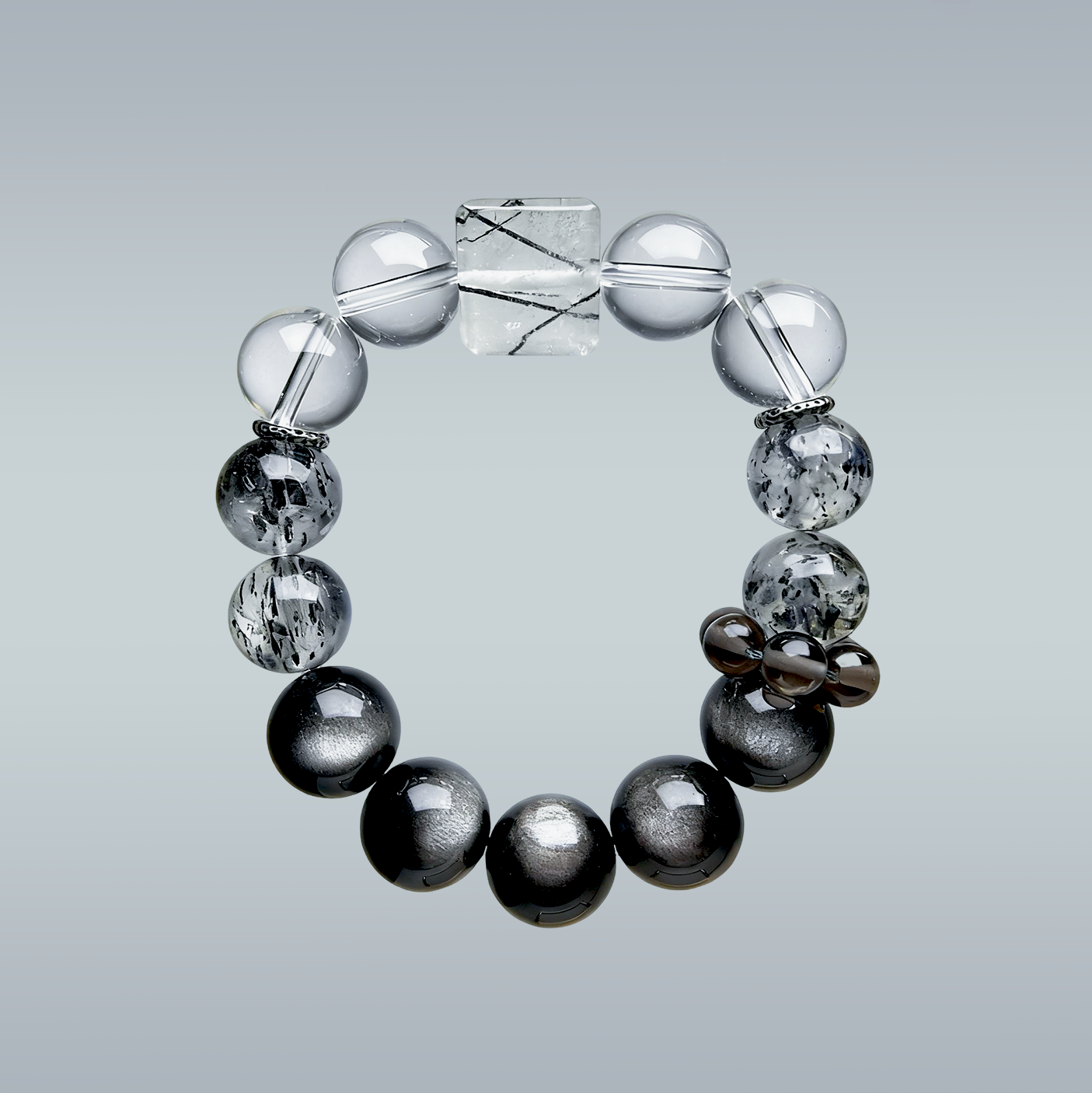 Hang-lay of Monochrome Vein bracelet in circular form displaying gradient from clear quartz to black obsidian