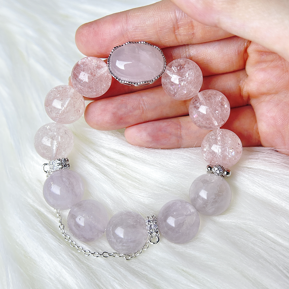 Elegant handmade crystal bracelet with rose quartz centerpiece, pink Azeztulite beads, and light purple rabbit hair rutilated quartz, resting on a white faux fur background.
