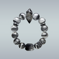 Full view of a Black Phantom Quartz and Rutilated Quartz bracelet with a double-terminated clear-black centerpiece, faceted black rutilated quartz bead, silver snake charm, and bow spacers on gradient background.