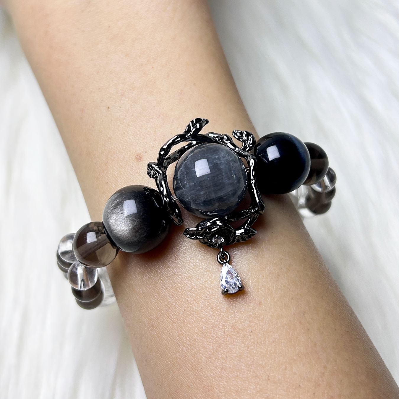 gray rabbit hair rutilated quartz and smoky quartz bracelet with decorative charm pendant.