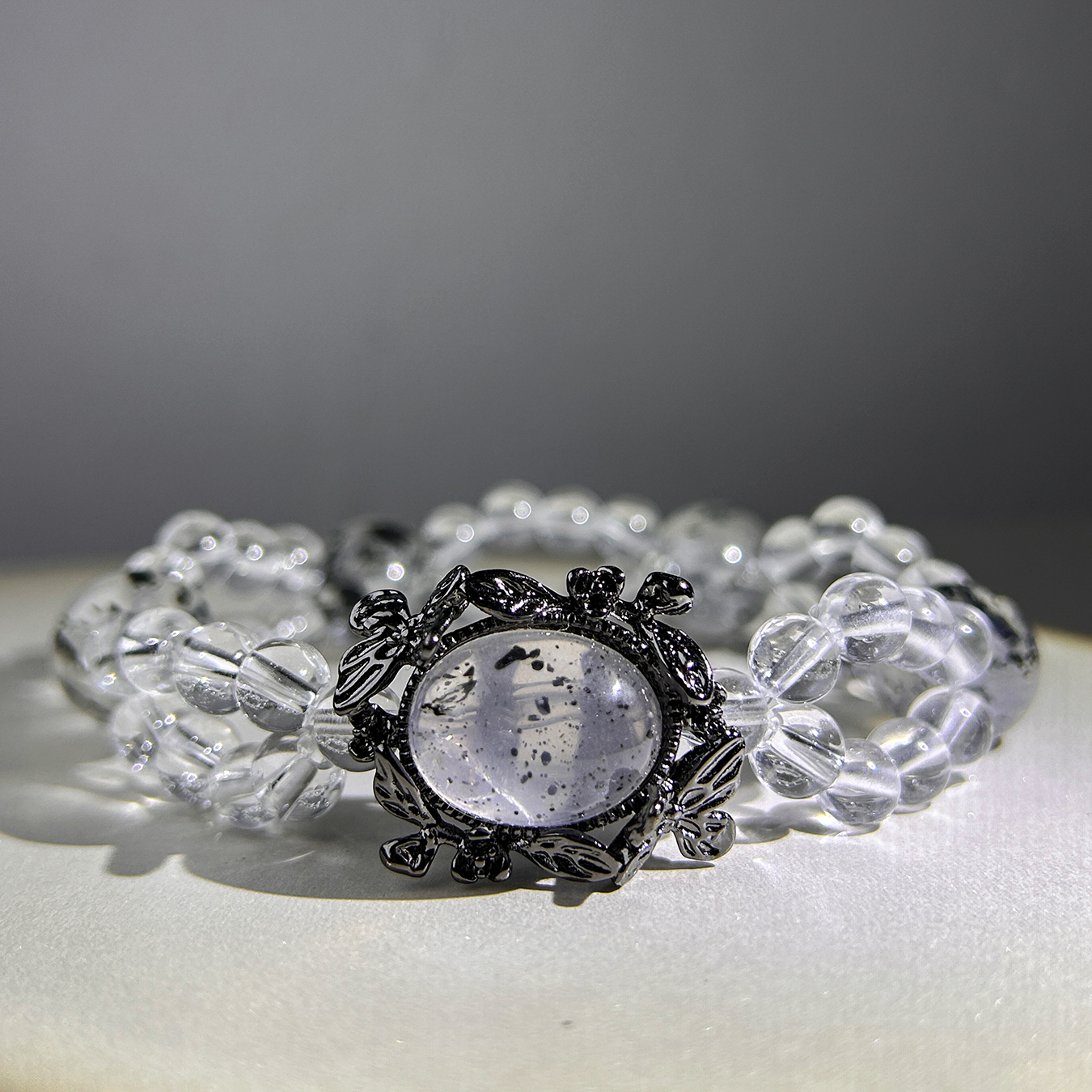 Noir Mist bracelet under soft light highlighting speckled Biotite Mica gemstone and quartz clarity.
