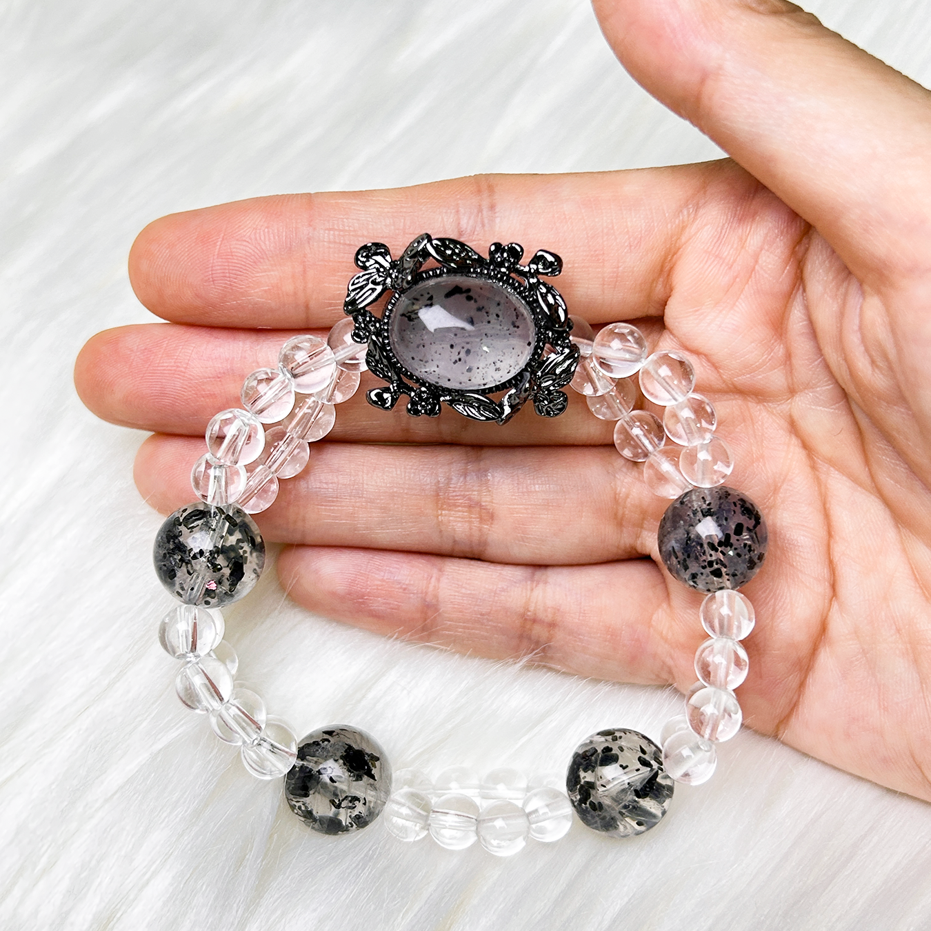 Noir Mist bracelet displayed in hand showing Biotite Mica centerpiece and crystal arrangement.