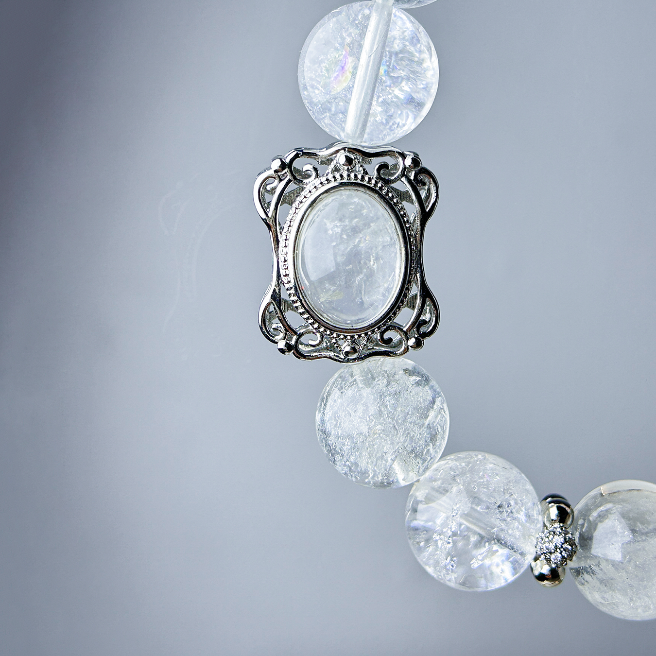 Rutilated quartz centerpiece glowing under soft light, paired with clear azeztulite beads.