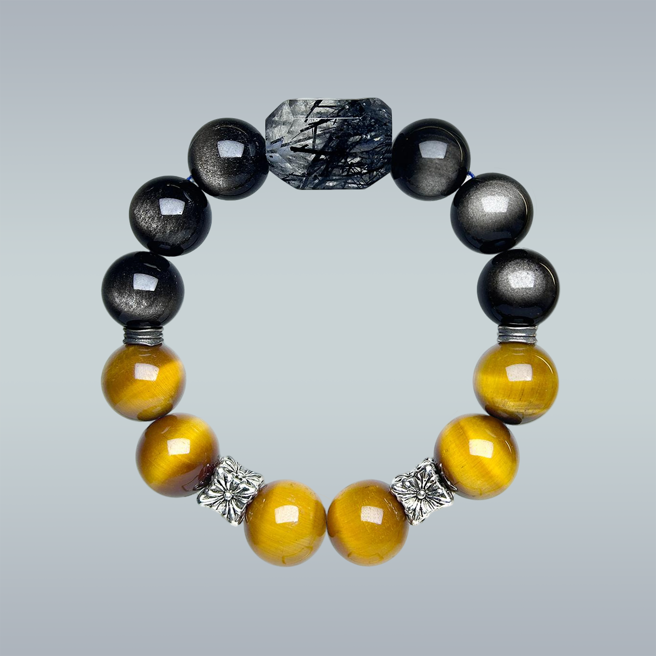 Hang-lay of the full crystal bracelet, combining yellow tiger’s eye, rutilated quartz centerpiece, cat’s eye, and black obsidian, with decorative silver spacers arranged in a harmonious circle.