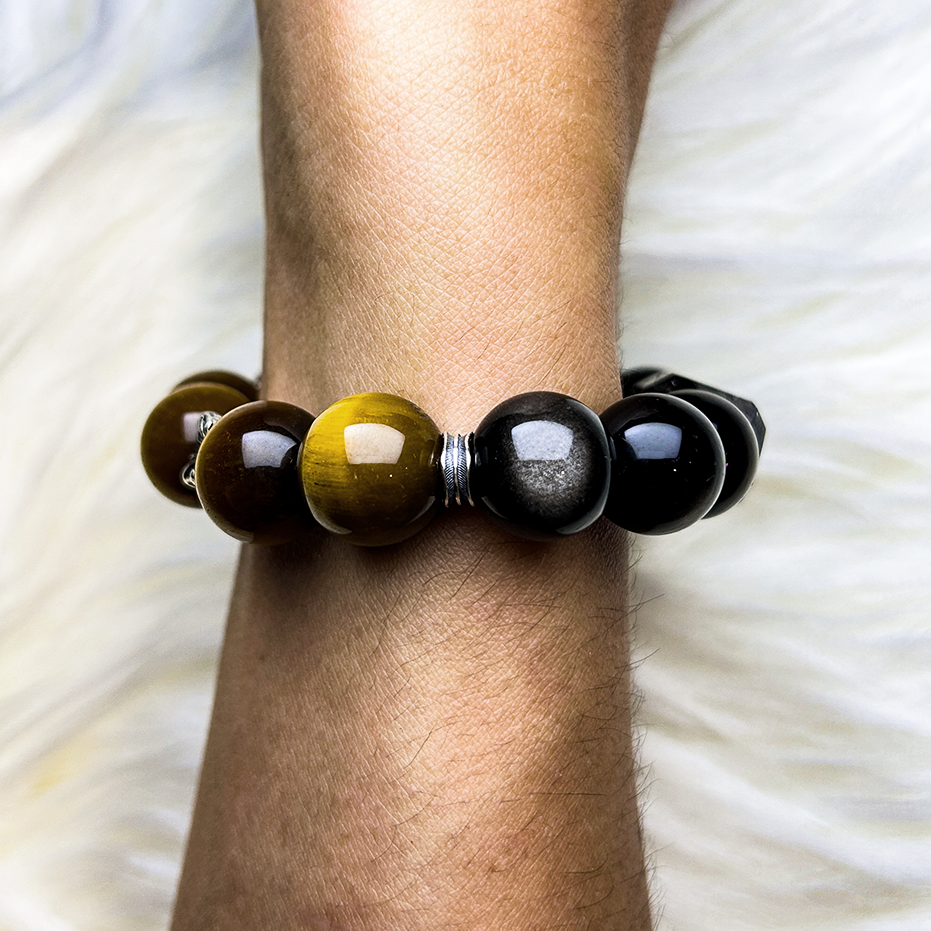 Side view of a handmade crystal bracelet combining yellow tiger’s eye, silver-gray cat’s eye beads, and black obsidian for a sleek and balanced energy design.