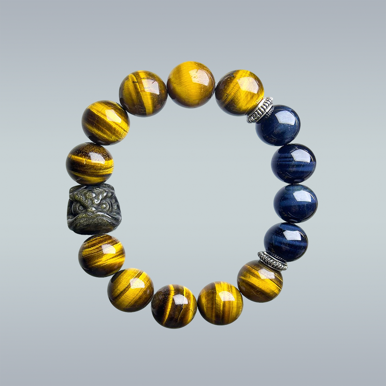 hang lay of handmade men bracelet composed yellow and blue of tiger’s eye, showcasing a black obsidian Pi Xiu charm and silver spacers.