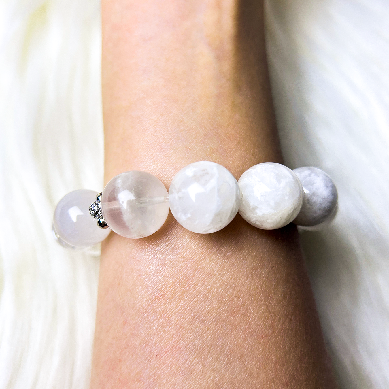 Wrist shot of the bracelet showing the white phantom quartz section, highlighting the gentle texture, faceted shine, and elegant neutral tones.