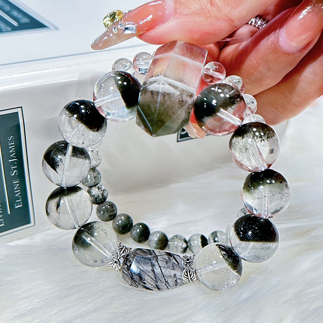 Double layered green phantom quartz bracelet holding on hand under warm lighting.