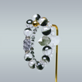 Double-layer bracelet with Green Phantom Quartz, Clear Quartz, and Clear Rutilated Quartz displayed on gold stand