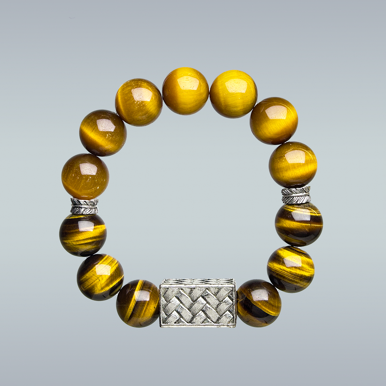 Bracelet with yellow tiger eye beads and silver centerpiece and spacers on a gray background
